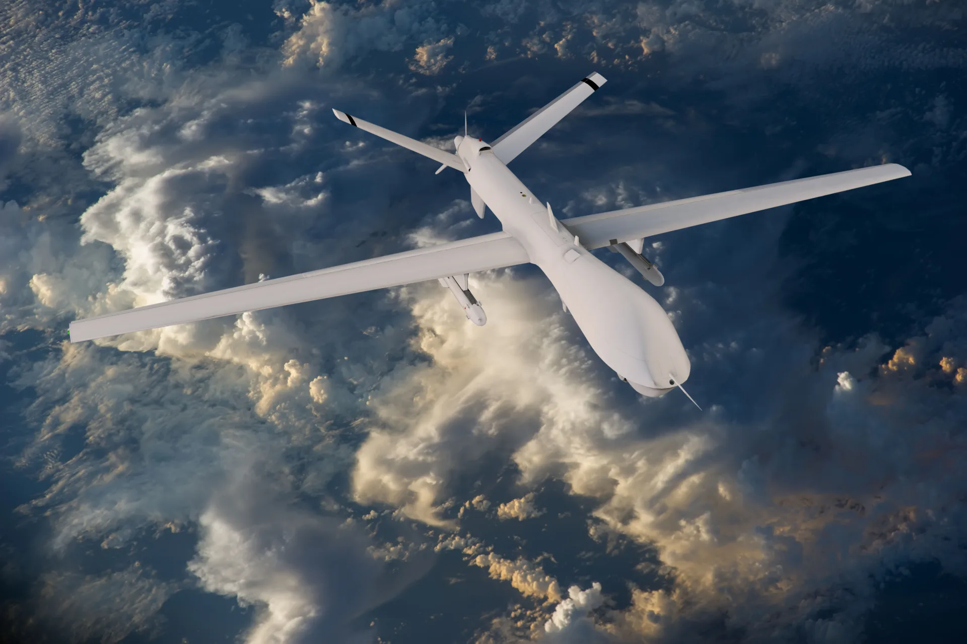 Military drone in flight above clouds